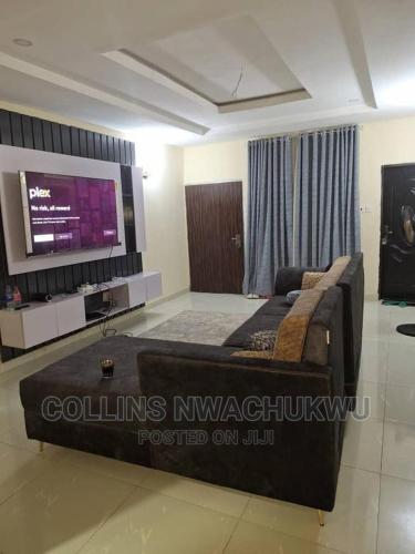 Galadima的住宿－Adriel Homes，客厅配有大床和平面电视。