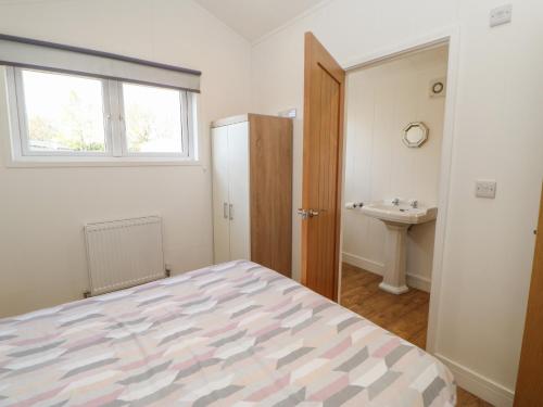 a bedroom with a bed and a sink and a window at Nidderdale Pod in Yarm