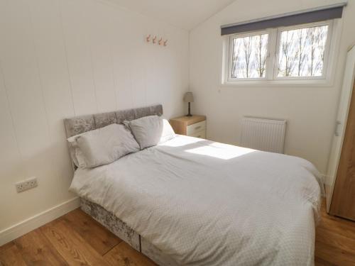 a white bed in a bedroom with a window at Levendale Pod in Yarm