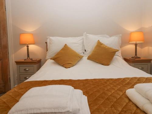a bedroom with a white bed with pillows and two lamps at Heatherlea in Keswick