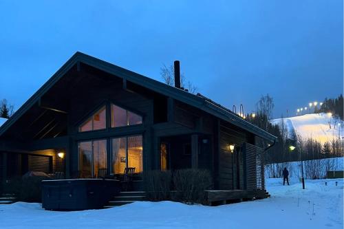 domek z bali na śniegu w nocy w obiekcie Villa Pohjoistuuli - 5+1 henkilölle, Luoteis-Himos Ski-in/out 56m² + 11m² w mieście Jämsä
