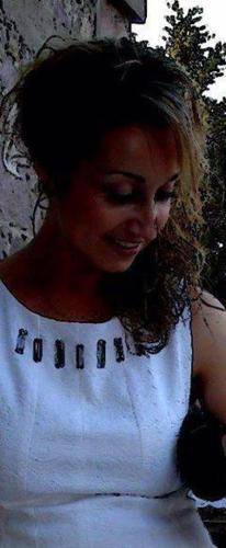 a woman in a white top is smiling at Karagiannaki in Skála Sykaminéas