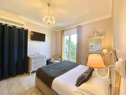a bedroom with a bed and a mirror and a window at Hotel du Soleil et Spa in Saint-Rémy-de-Provence