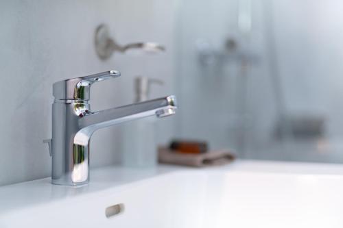 a bathroom sink with a silver faucet at Hotel Restaurant Sokrates in Güttingen