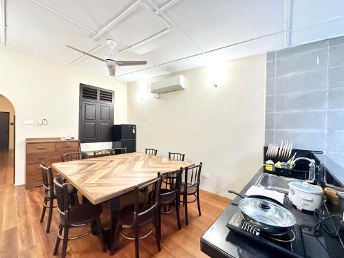 eine Küche mit einem großen Holztisch in einem Zimmer in der Unterkunft Madras Inn 58-1 Private Bathroom in George Town