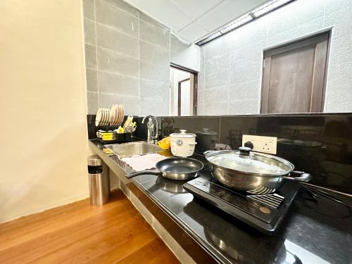 eine Küche mit zwei Töpfen und Pfannen auf einer Theke in der Unterkunft Madras Inn 58-1 Private Bathroom in George Town