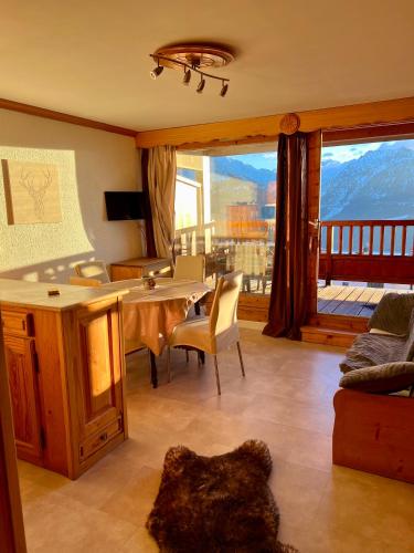 un salon avec une table et une grande fenêtre dans l'établissement Studio cosy Centre station de ski La Rosière 1850 vue magnifique plein Sud, à Montvalezan