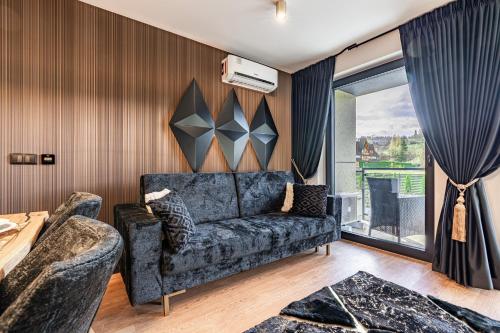 a living room with a couch and a window at Aparthotel Diamond SPA Aqua in Białka Tatrzanska