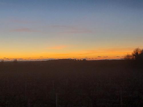 a sunset in a field with the sky at Gite chez Lea in Saint-Seurin-de-Cadourne