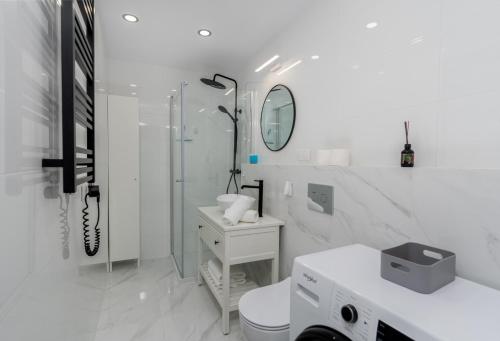 biała łazienka z prysznicem i toaletą w obiekcie Wrzesińska Luxury Apartment w Krakowie