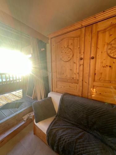 - un salon avec un canapé et un mur en bois dans l'établissement Studio cosy Centre station de ski La Rosière 1850 vue magnifique plein Sud, à Montvalezan