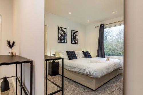 Llanberis Grove - Stylish 4 Bedroom House, close to the city centre في نوتينغهام: غرفة نوم بسرير ونافذة