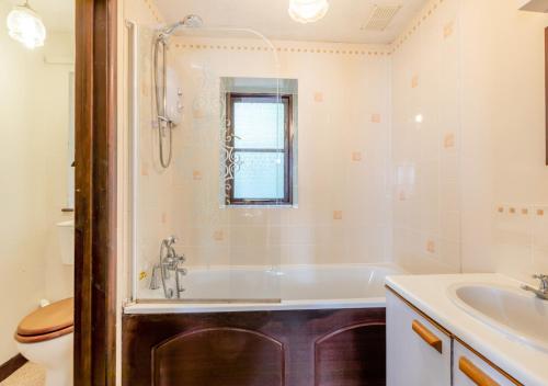 a bathroom with a tub and a sink and a toilet at The Carriage House Upcott House in Barnstaple