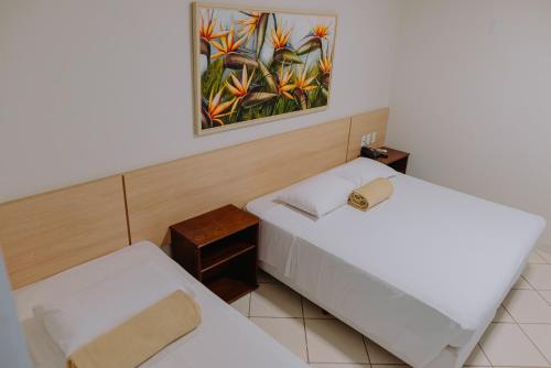 a room with two beds and a painting on the wall at Lago Da Palma in Palmas