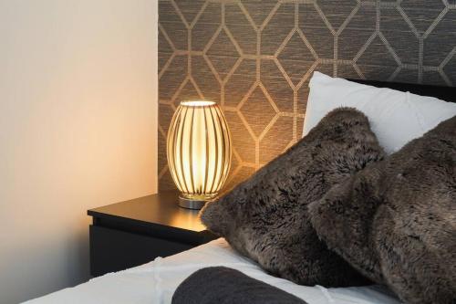 a lamp on a table next to a bed at Stylish modern home in Sheffield in Sheffield