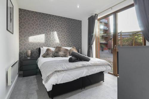 a bedroom with a bed and a large window at Stylish modern home in Sheffield in Sheffield