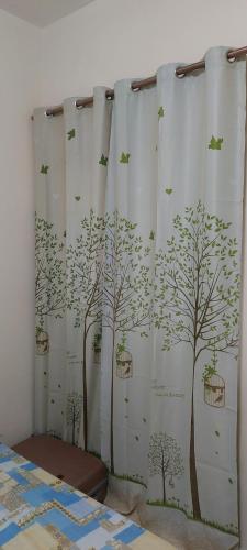 a bedroom with a shower curtain with trees and birds at VACATION HOME STAY AT SHRJAH DUBAI BORDER By mauon tourism in Sharjah