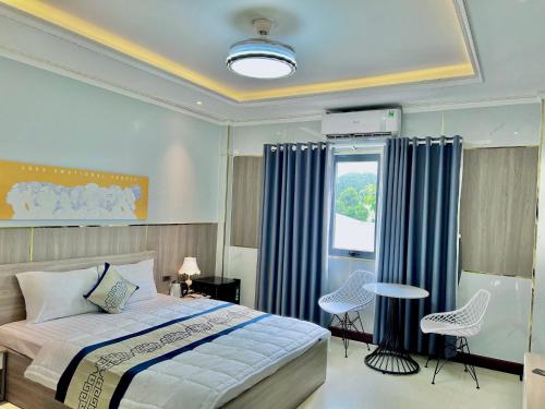 1 dormitorio con 1 cama, mesa y sillas en Biển Sao 2 Hotel GV, en Ho Chi Minh