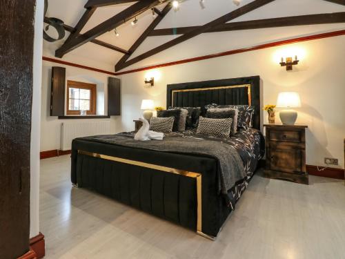 a bedroom with a large black bed in a room at Winding Wheel Cottage in Blythe