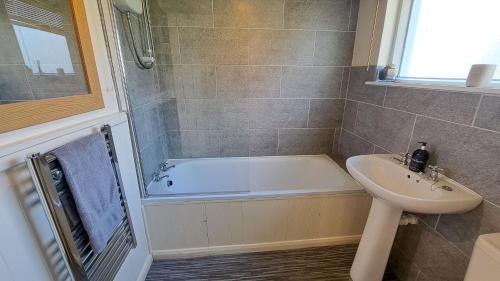 a bathroom with a bath tub and a sink at The Studio at Loe Beach in Feock