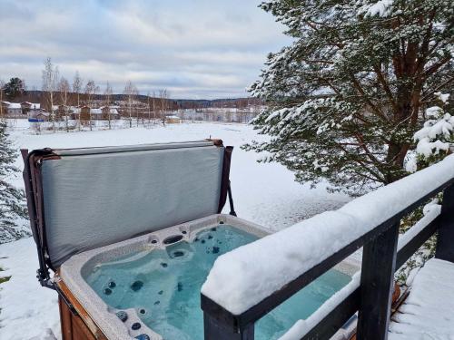 a hot tub sitting on a rail in the snow at Villa Alppihimos - 6 henkilölle, Keski-Himos, 45m² + 33m² in Jämsä