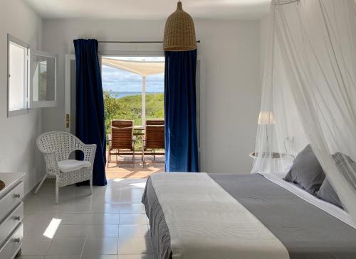 a bedroom with a bed and a view of a patio at Voga Mari - Astbury Formentera in Playa Migjorn