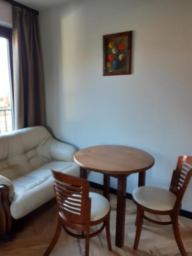 a living room with a table and a couch at Arte Gdańsk in Gdańsk