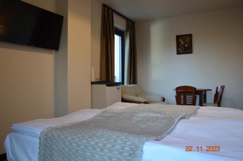 a bedroom with a white bed with a flat screen tv at Arte Gdańsk in Gdańsk