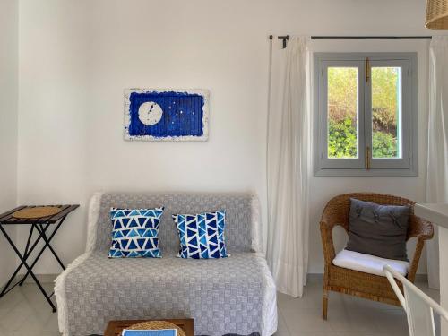 a living room with a couch and a clock on the wall at Voga Mari - Astbury Formentera in Playa Migjorn