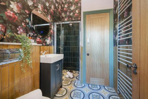 a bathroom with a sink and a cat laying on the floor at The Rose Nobel - 1 Bed Studio Apartment in Bristol by Mint Stays in Bristol