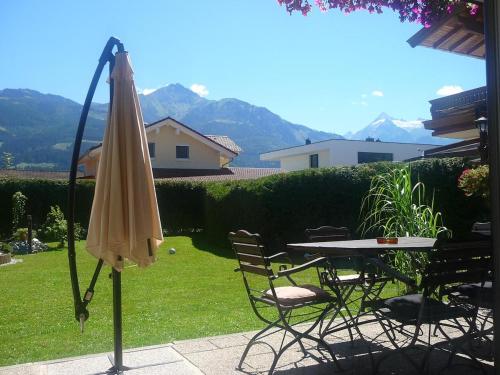 un patio con sombrilla, mesa y sillas en Apartment-Alpenfantasie, en Zell am See