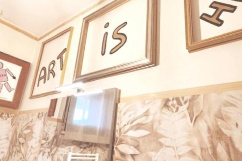 a room with three pictures on the wall and a wall with at [3' a piedi dal mare] CASITA DEL MAR...Mare & Arte in Grottammare
