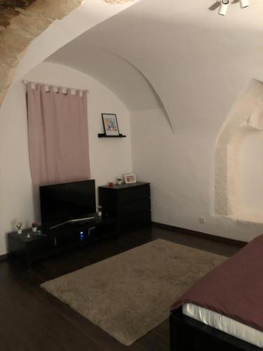 a bedroom with a bed and a television in a room at Nuovo Casa in Sopron