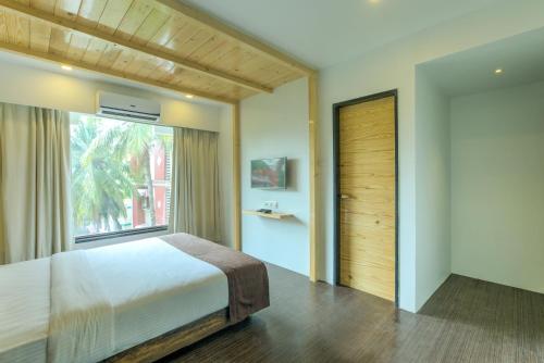 a bedroom with a large bed and a window at Crown Inn in Panvel