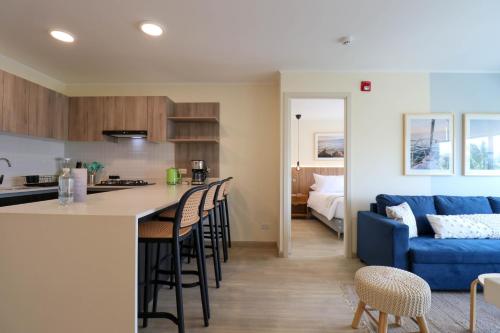 a kitchen and a living room with a blue couch at El Sol by Wynwood House in Lima