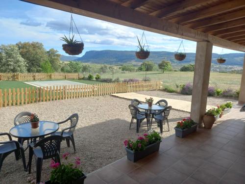eine Terrasse mit Tischen und Stühlen und Aussicht in der Unterkunft CASA RURAL LA HOJA EL VALLE in Valdecaballeros