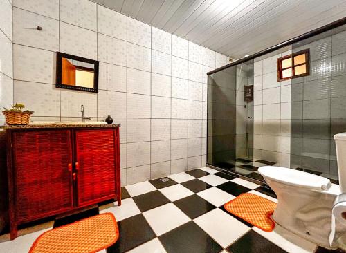 a bathroom with a toilet and a glass shower at Otima casa com praia particular em Camacari BA in Camaçari