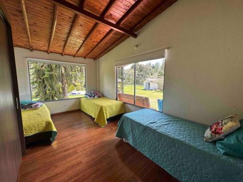 um quarto com 2 camas e uma grande janela em Casa de Campo Piedras Blancas em Medellín