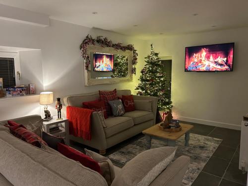 a living room with a couch and a christmas tree at Tosside Fold Farm Cottage in Skipton