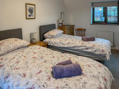 sypialnia z 2 łóżkami i poduszkami w obiekcie Lavender Cottage w mieście Stretton on Fosse