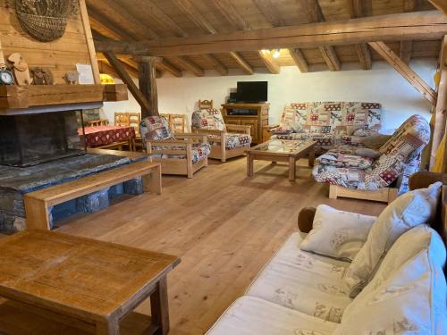 een grote woonkamer met banken en een open haard bij Chalet des Laix in La Rosière