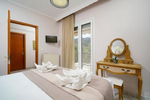 a bedroom with a bed with a mirror and a table at Sunside House in Skala Kallirachis