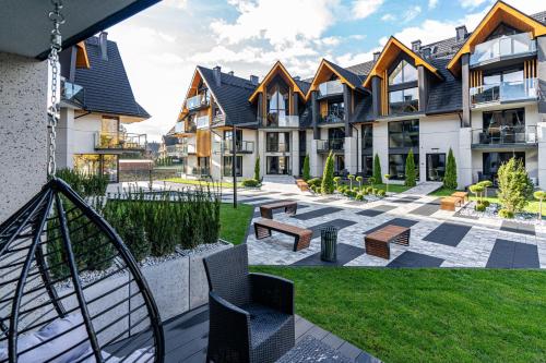 an apartment building with a courtyard with benches at Aparthotel Diamond SPA Aqua in Białka Tatrzanska