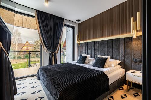 a bedroom with a bed and a large window at Aparthotel Diamond SPA Aqua in Białka Tatrzanska