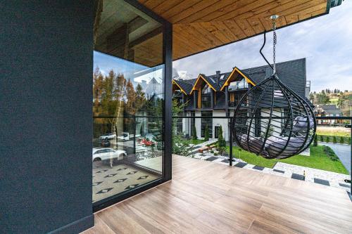 a house with a large glass window with a swing at Aparthotel Diamond SPA Aqua in Białka Tatrzanska