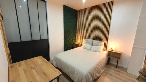 Dormitorio pequeño con cama y mesa en Le Cinq Bis : centre-ville*proche gare*parking, en Vesoul