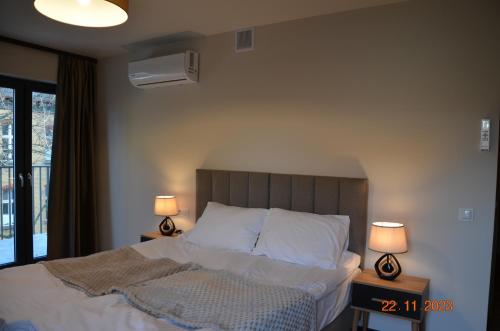 a bedroom with a bed with two lamps on tables at Arte Gdańsk in Gdańsk