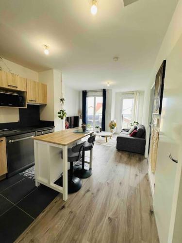 une cuisine avec une table et un salon dans l'établissement Cozy appart near la defense & Paris, à Bezons