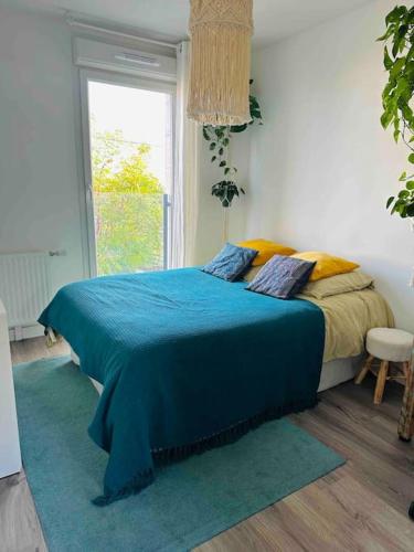 une chambre avec un lit bleu avec une fenêtre dans l'établissement Cozy appart near la defense & Paris, à Bezons