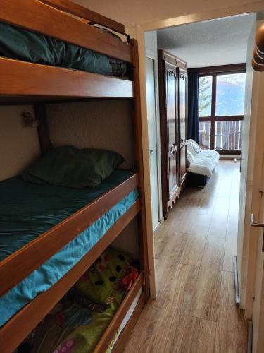 a bedroom with two bunk beds and a balcony at Super Sauze charmant studio en bas des pistes in Enchastrayes